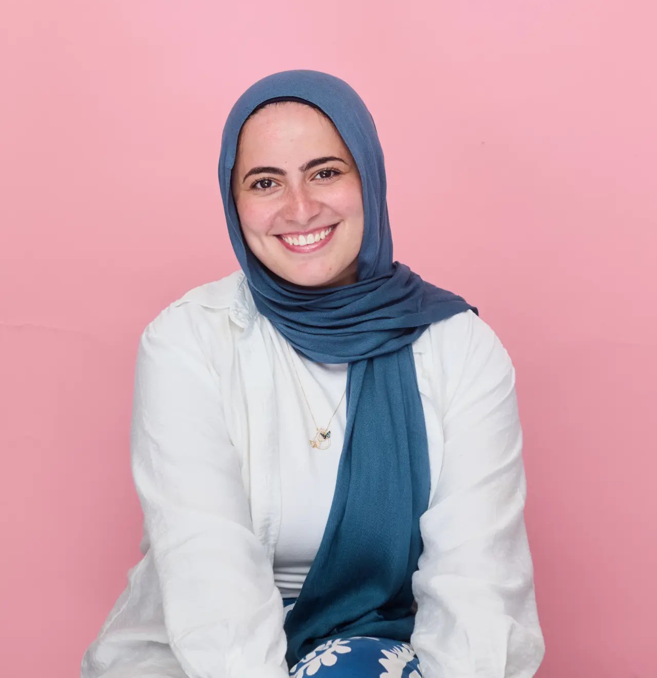 Sarah Fahmi seated against a soft blush backdrop